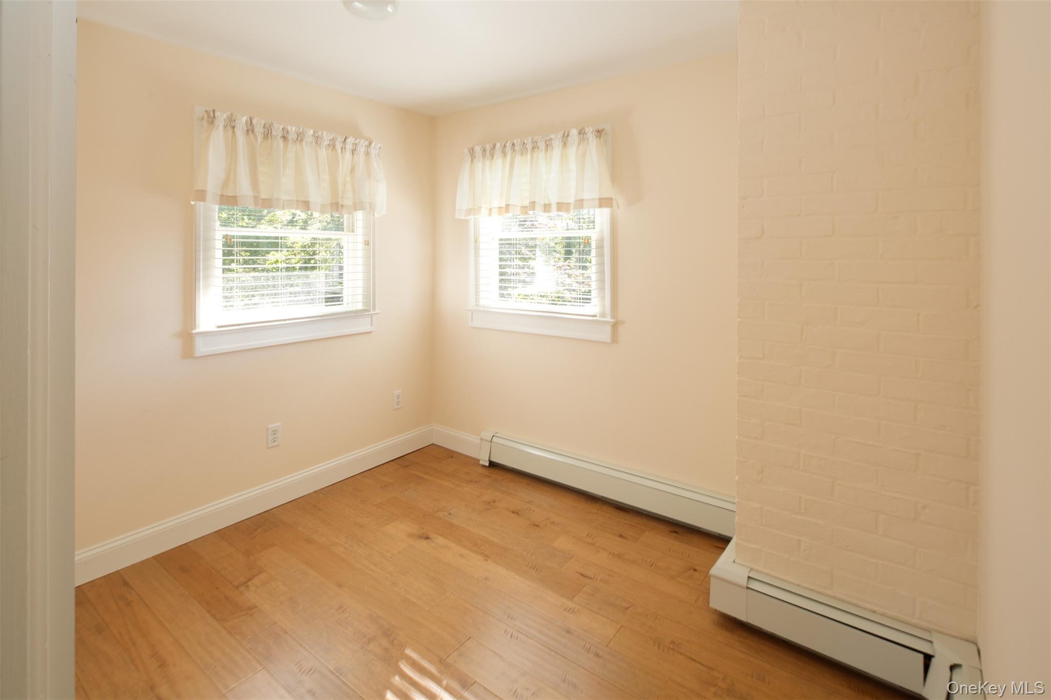1 Canal Road Hampton Bays, NY 11946 - Photo 24 of 50 Empty room featuring a baseboard heating unit and light wood-style flooring