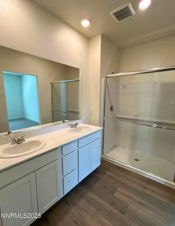 a bathroom with double vanity sink and a mirror
