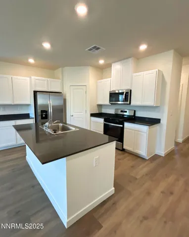 a kitchen with kitchen island a stove a refrigerator a sink and a refrigerator