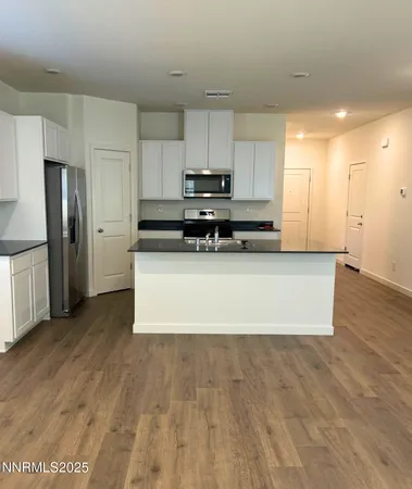 a large kitchen with stainless steel appliances a refrigerator and a stove top oven