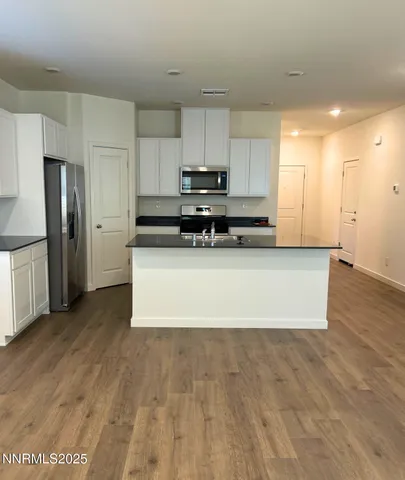 a large kitchen with stainless steel appliances a refrigerator and a stove top oven