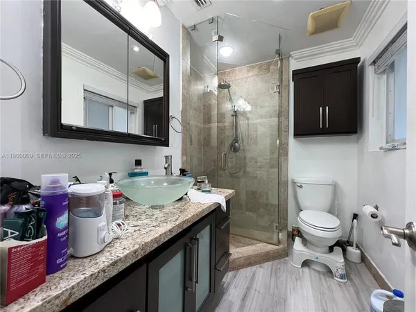 a kitchen with stainless steel appliances granite countertop wooden cabinets a sink dishwasher and a stove top oven with wooden floor