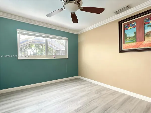 a view of empty room with window and ceiling fan