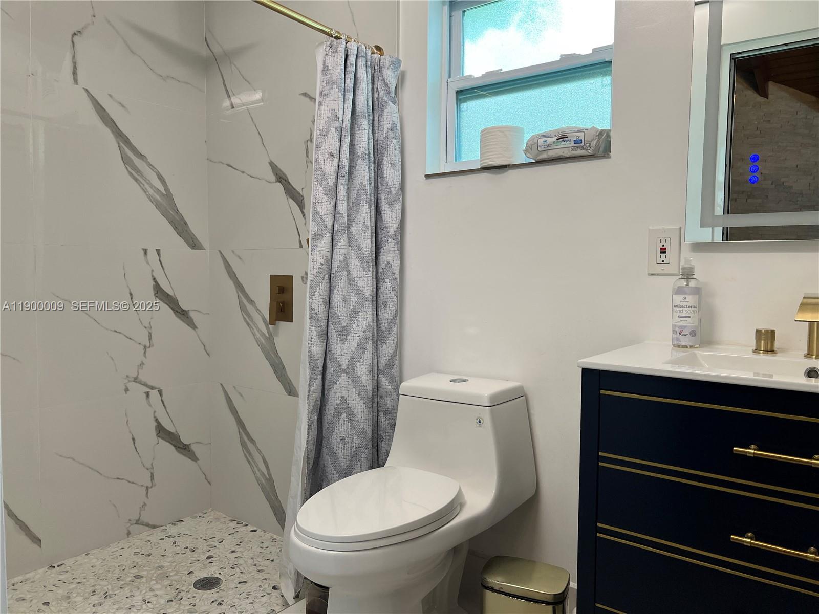 10220 Southwest 160th Street, Unit 10220 Miami, FL 33157 - Photo 41 of 57 a white toilet sitting next to a bathroom sink and a mirror