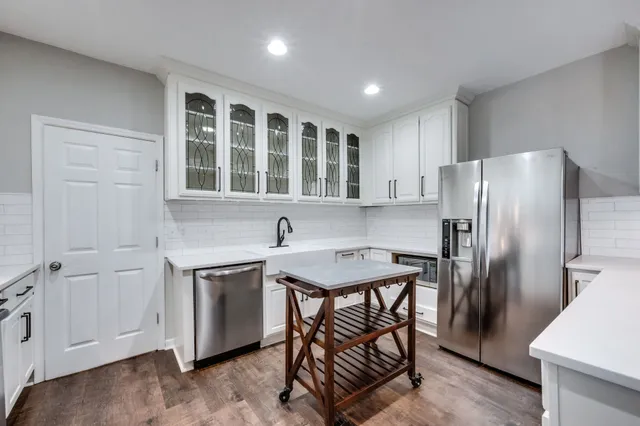 a kitchen with a table chairs refrigerator and microwave