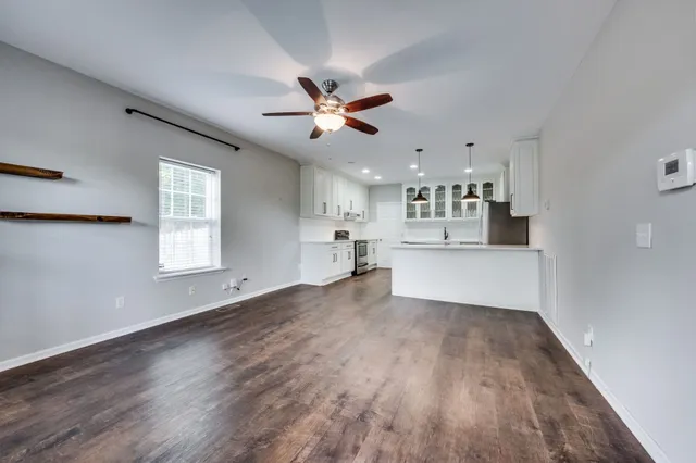 a view of a kitchen with wooden floor and a kitchen space