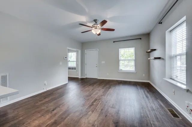 a kitchen with stainless steel appliances granite countertop a sink a stove a refrigerator and a wooden floors