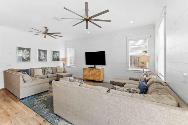 a kitchen with stainless steel appliances kitchen island granite countertop a refrigerator a stove top oven and a dining table with wooden floor