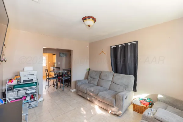 a living room with furniture and a dining table