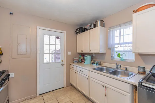 a kitchen with a sink white cabinets and white appliances