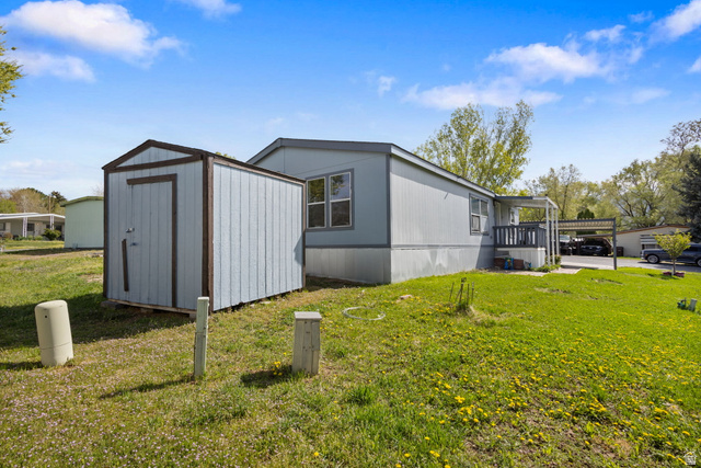2600 North Hill Field Road, Unit 86 Layton, UT 84041 - Photo 25 of 25 View of side of property with a yard, a shed, and a carport