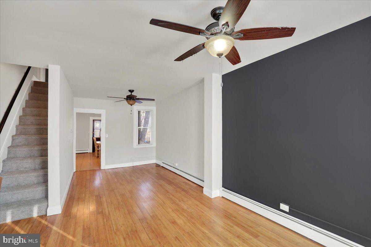 623 Bay Street Lancaster, PA 17603 - Photo 4 of 23 a view of a big room with wooden floor ceiling fan and windows