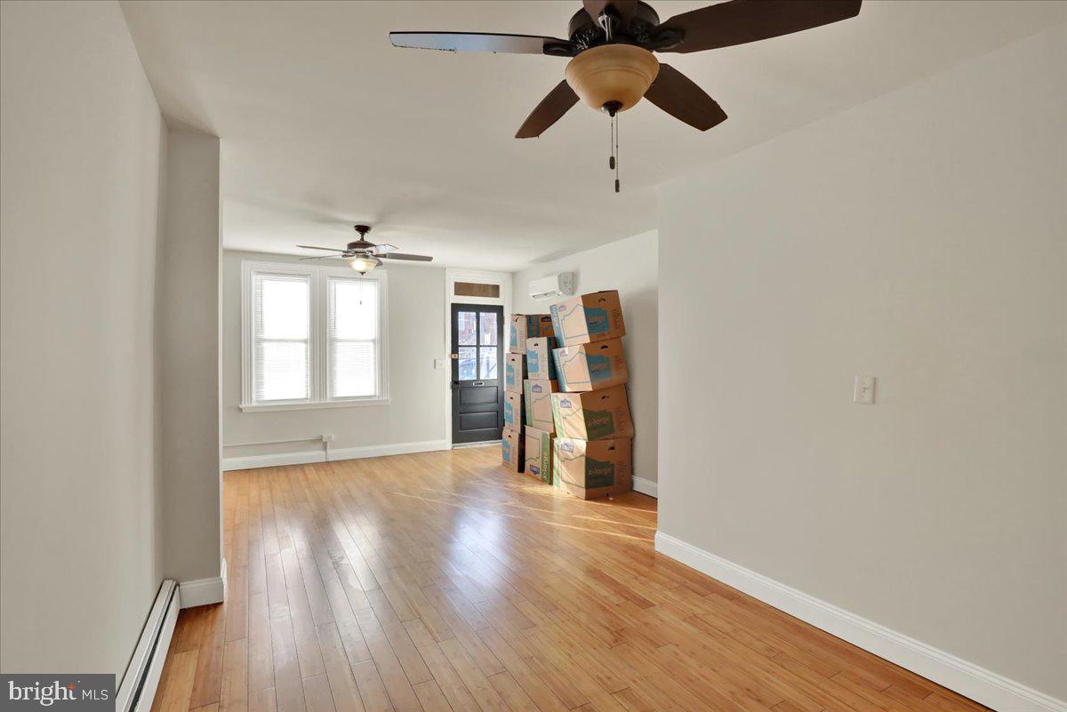 623 Bay Street Lancaster, PA 17603 - Photo 6 of 23 an empty room with wooden floor closet chandelier fan and windows