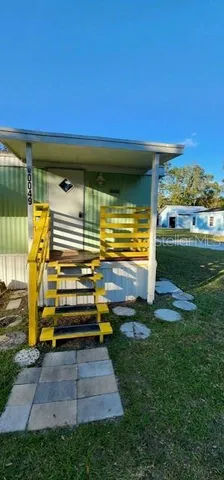 a yellow and red umbrella sitting in the middle of a yard