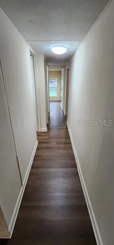 a view of a hallway with wooden floor