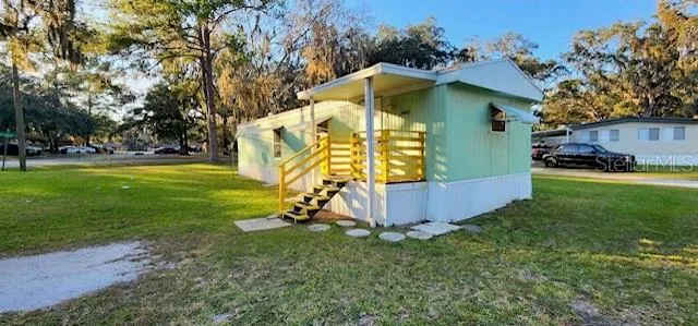 a view of a house with a yard and sitting area