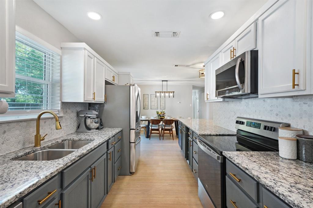 a kitchen with stainless steel appliances granite countertop sink stove top oven and microwave