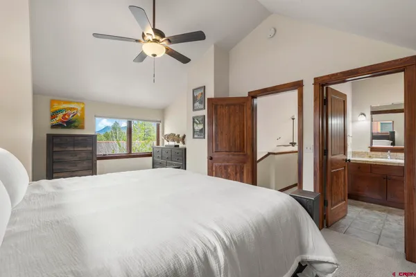 a bedroom with a large bed dresser and a chandelier