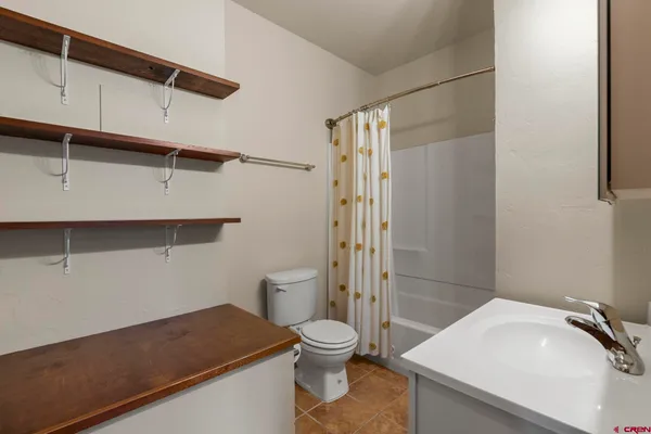 a bathroom with a granite countertop sink toilet a mirror and shower