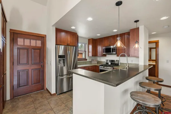 a kitchen with stainless steel appliances granite countertop a sink refrigerator and cabinets