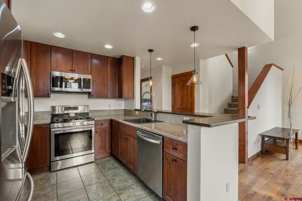 a kitchen with stainless steel appliances granite countertop a sink stove and refrigerator