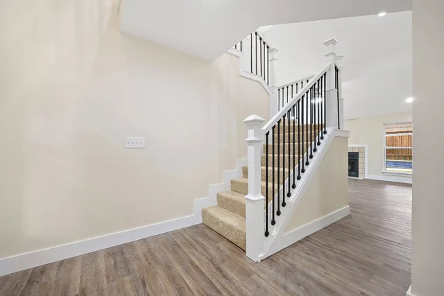 a view of a hallway with wooden floor and white walls