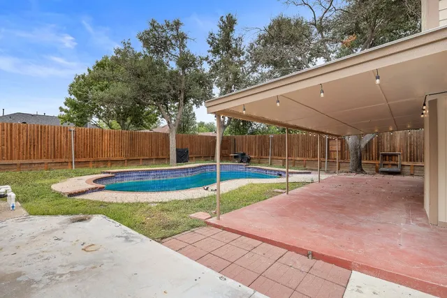 a view of a backyard with swimming pool