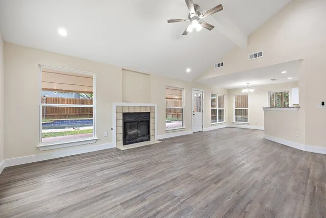a view of an empty room with a fireplace and a window