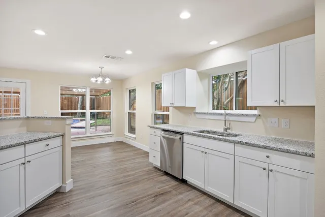 a view of a kitchen counter space a sink wooden floor and appliances