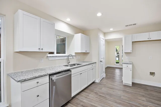a kitchen with granite countertop a sink and cabinets