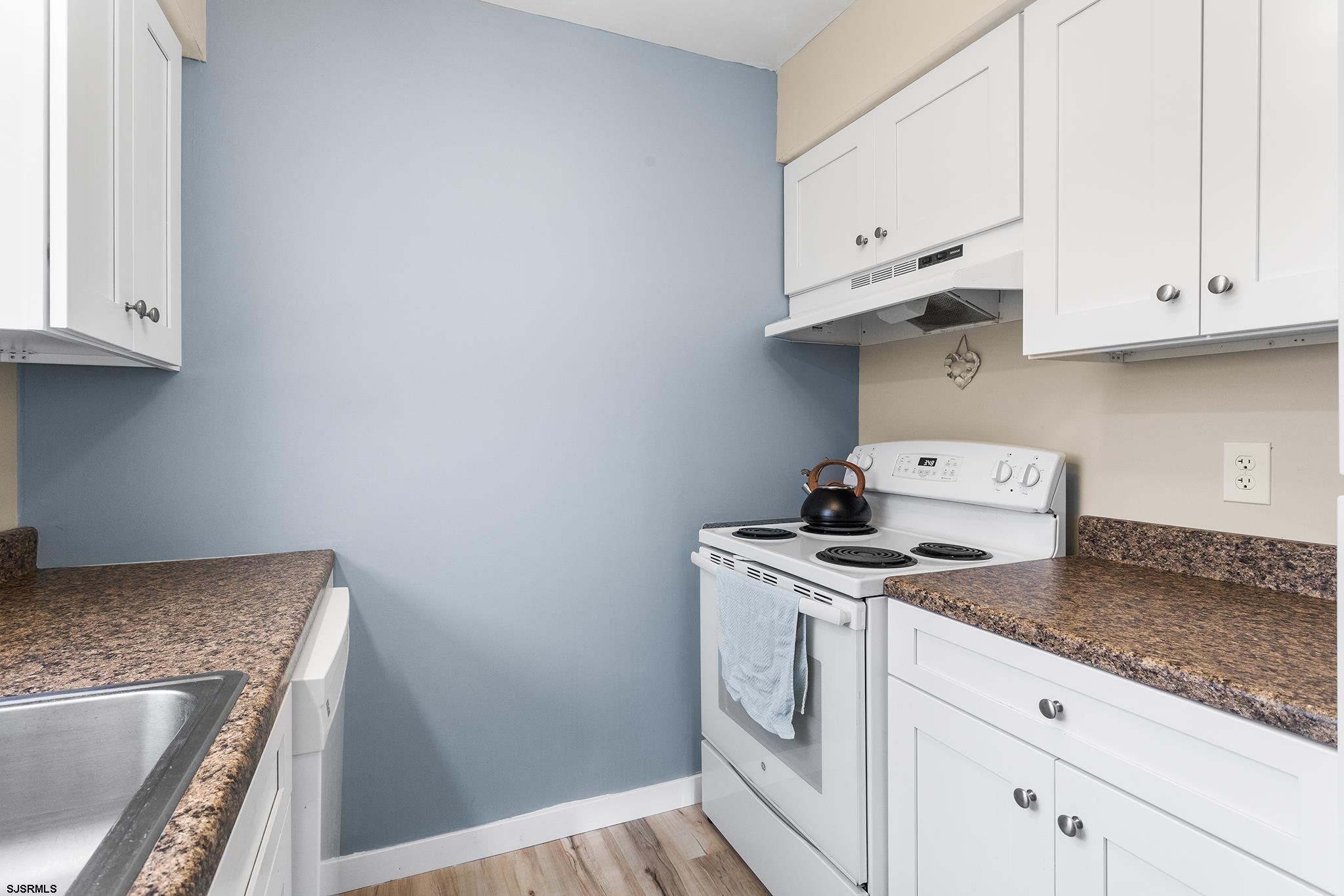 4611 Schooner Road, Unit 2 Brigantine, NJ 08203 - Photo 12 of 25 a kitchen with granite countertop white cabinets and a stove