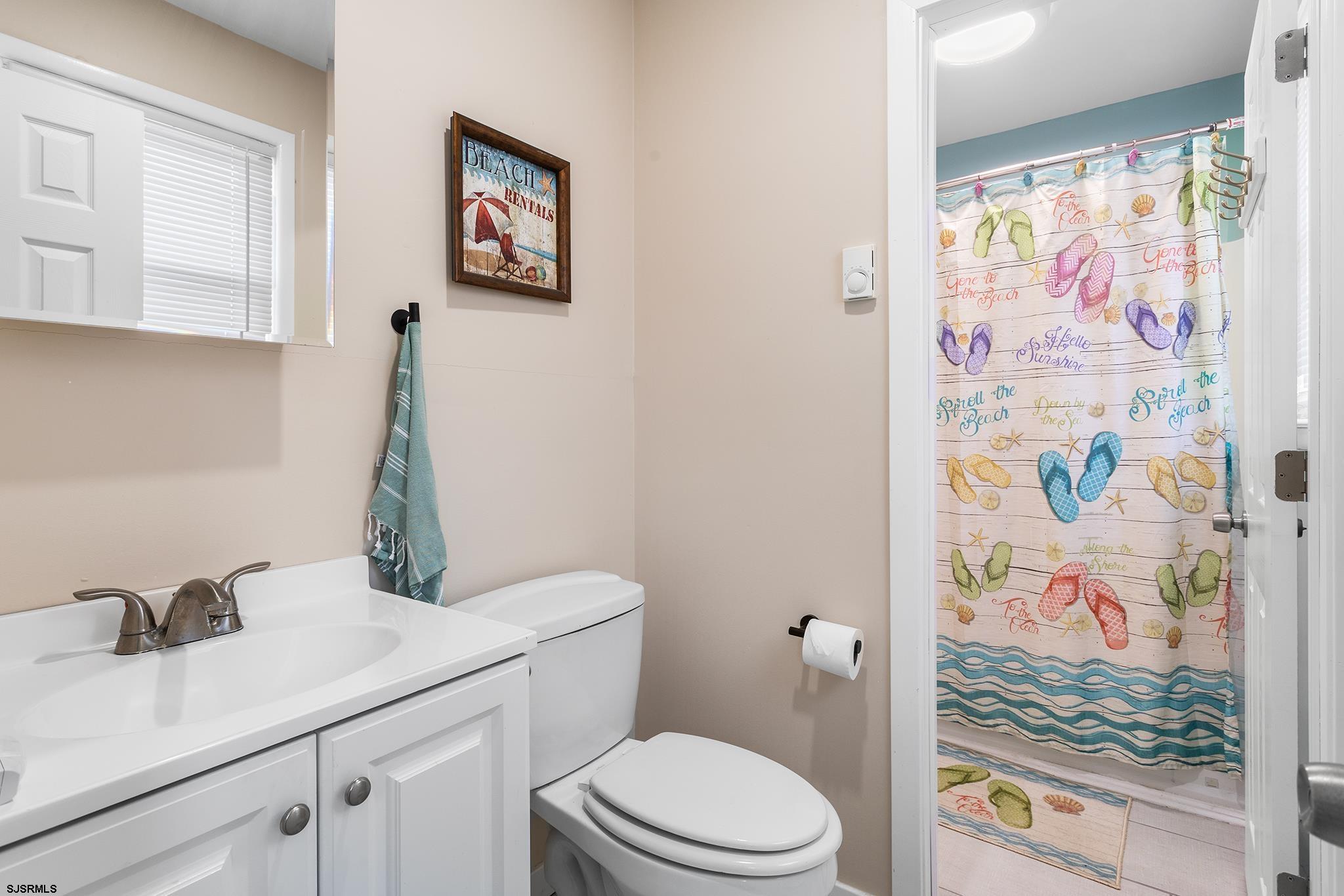 4611 Schooner Road, Unit 2 Brigantine, NJ 08203 - Photo 16 of 25 a bathroom with a sink mirror vanity and toilet