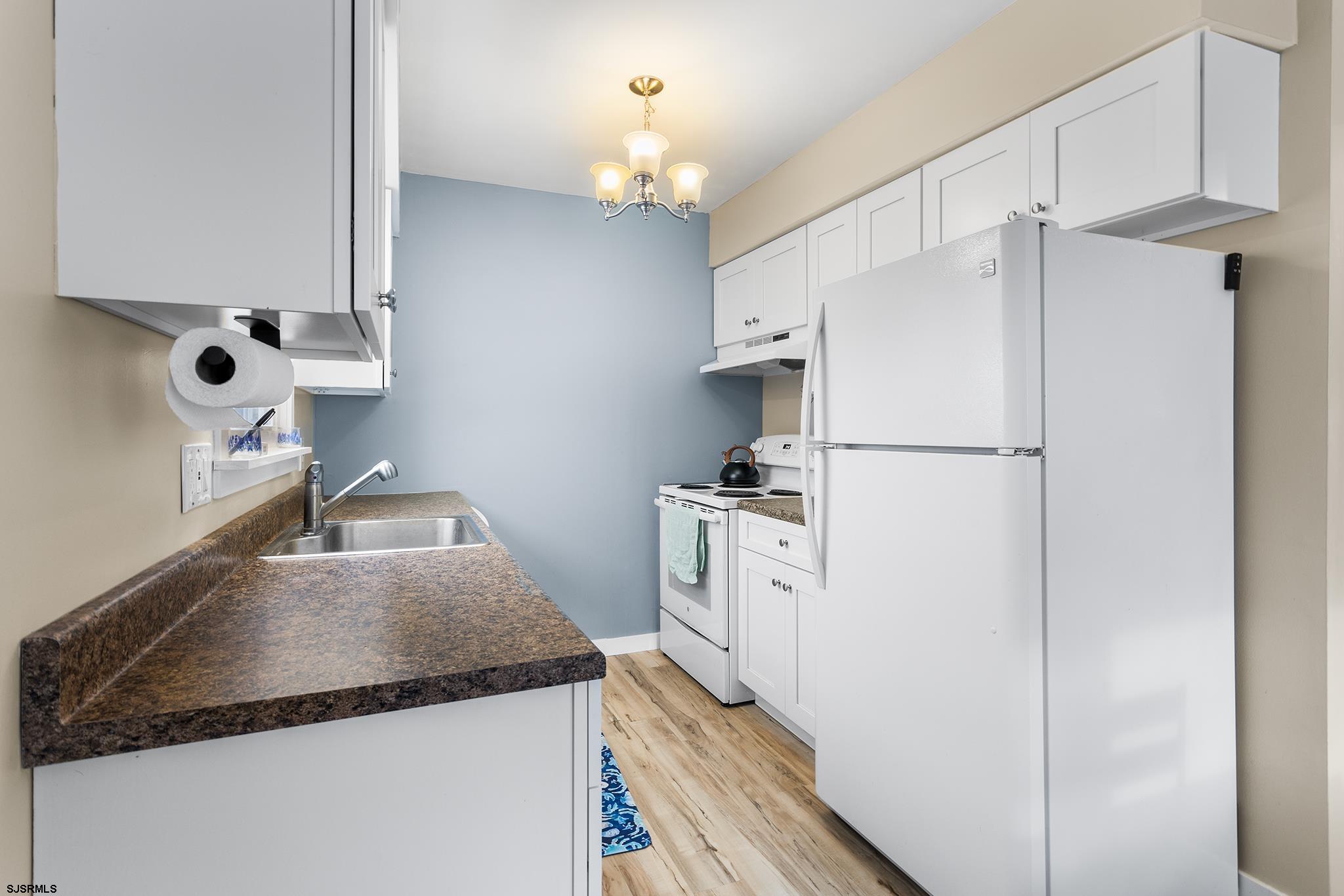 4611 Schooner Road, Unit 2 Brigantine, NJ 08203 - Photo 10 of 25 a kitchen with granite countertop a refrigerator a sink and dishwasher