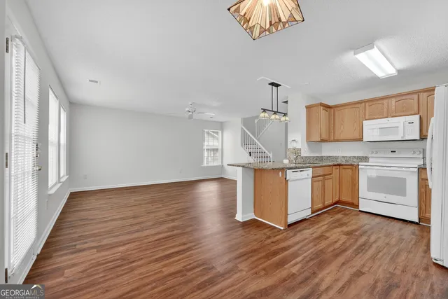a kitchen with wooden floors and white cabinets
