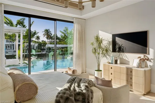 a bedroom with furniture and large windows