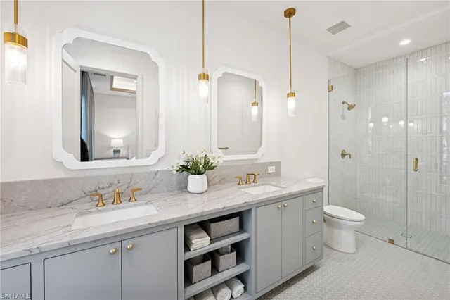 a bathroom with a granite countertop sink a toilet and a mirror