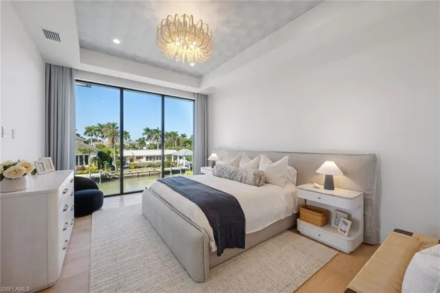 a bedroom with a bed and a chandelier