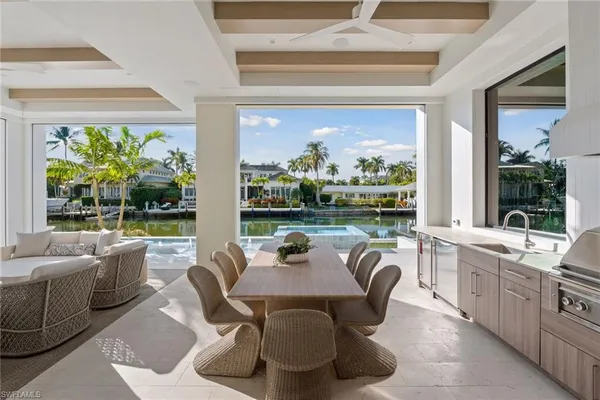 a living room with patio furniture and a large window