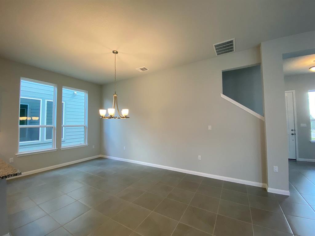 320 Creek Road, Unit 303 Dripping Springs, TX 78620 - Photo 13 of 28 an empty room with chandelier fan and windows