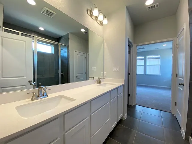 a bathroom with double vanity sinks and a mirror