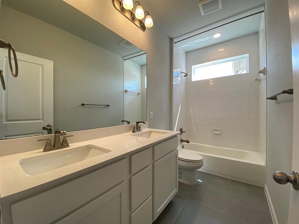 320 Creek Road, Unit 303 Dripping Springs, TX 78620 - Photo 22 of 28 a bathroom with a double vanity sink toilet mirror and bathtub