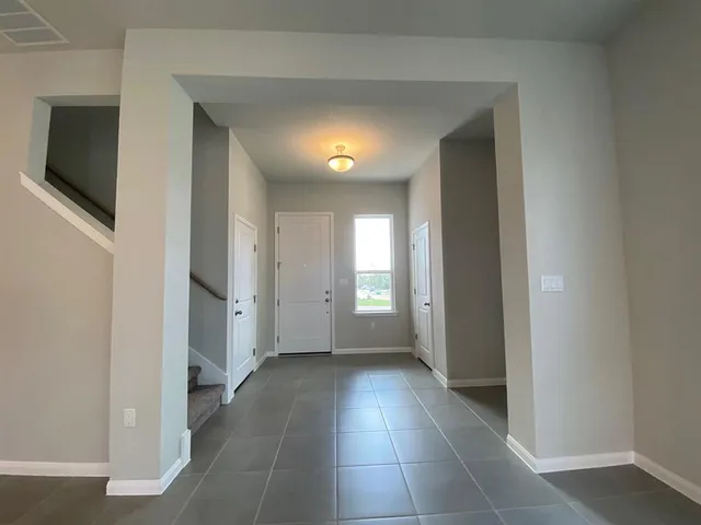 a view of a hallway with wooden floor and a flat screen tv