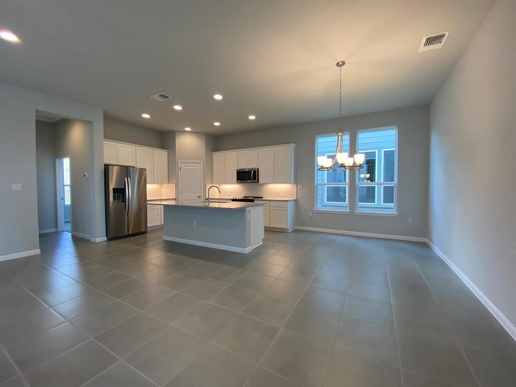 320 Creek Road, Unit 303 Dripping Springs, TX 78620 - Photo 5 of 28 a view of a kitchen with a sink and an empty room