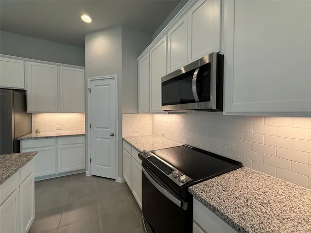 a kitchen with granite countertop a sink and steel appliances