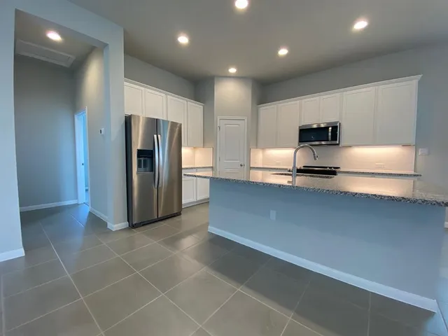 a kitchen with stainless steel appliances a refrigerator and a stove top oven