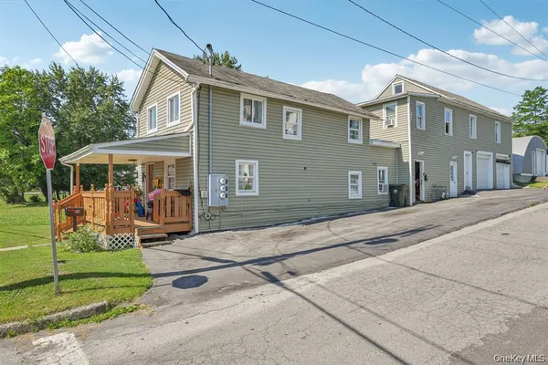 a view of a white house with a yard in front of it