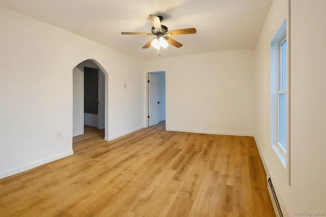 a view of an empty room with a chandelier fan