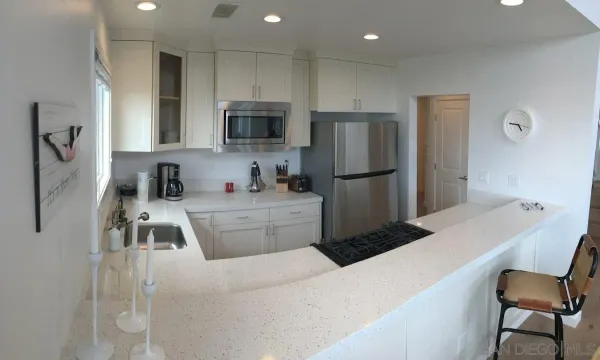 a kitchen with stainless steel appliances a refrigerator stove microwave and sink