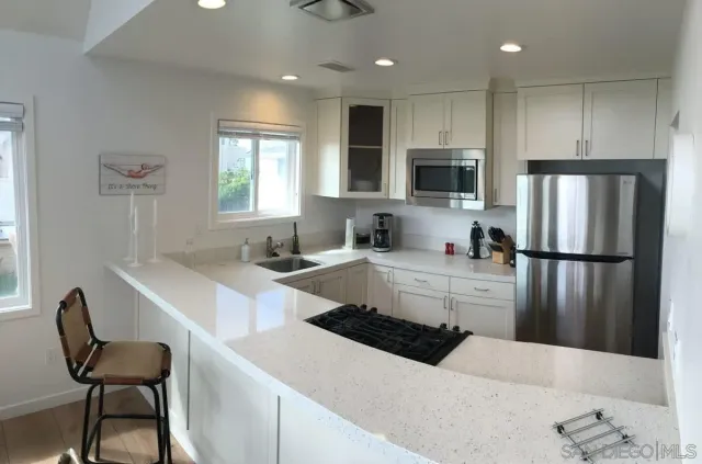 a large kitchen with a large window and stainless steel appliances