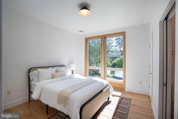 a bedroom with a bed and a large window